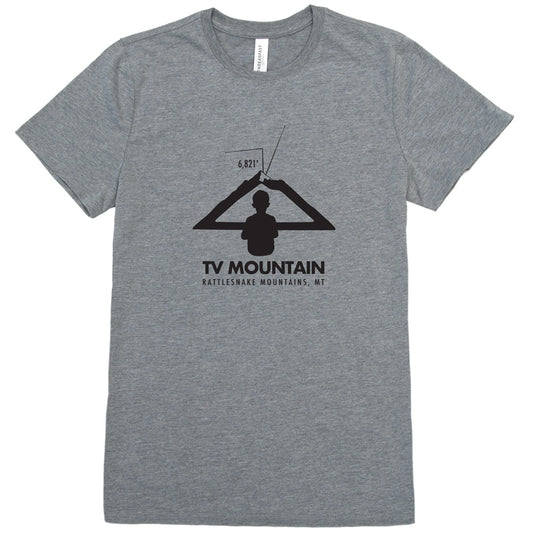 Image of a boy looking at a mountain as if it is a television to represent TV Mountain in Missoula, MT on a gray t-shirt.